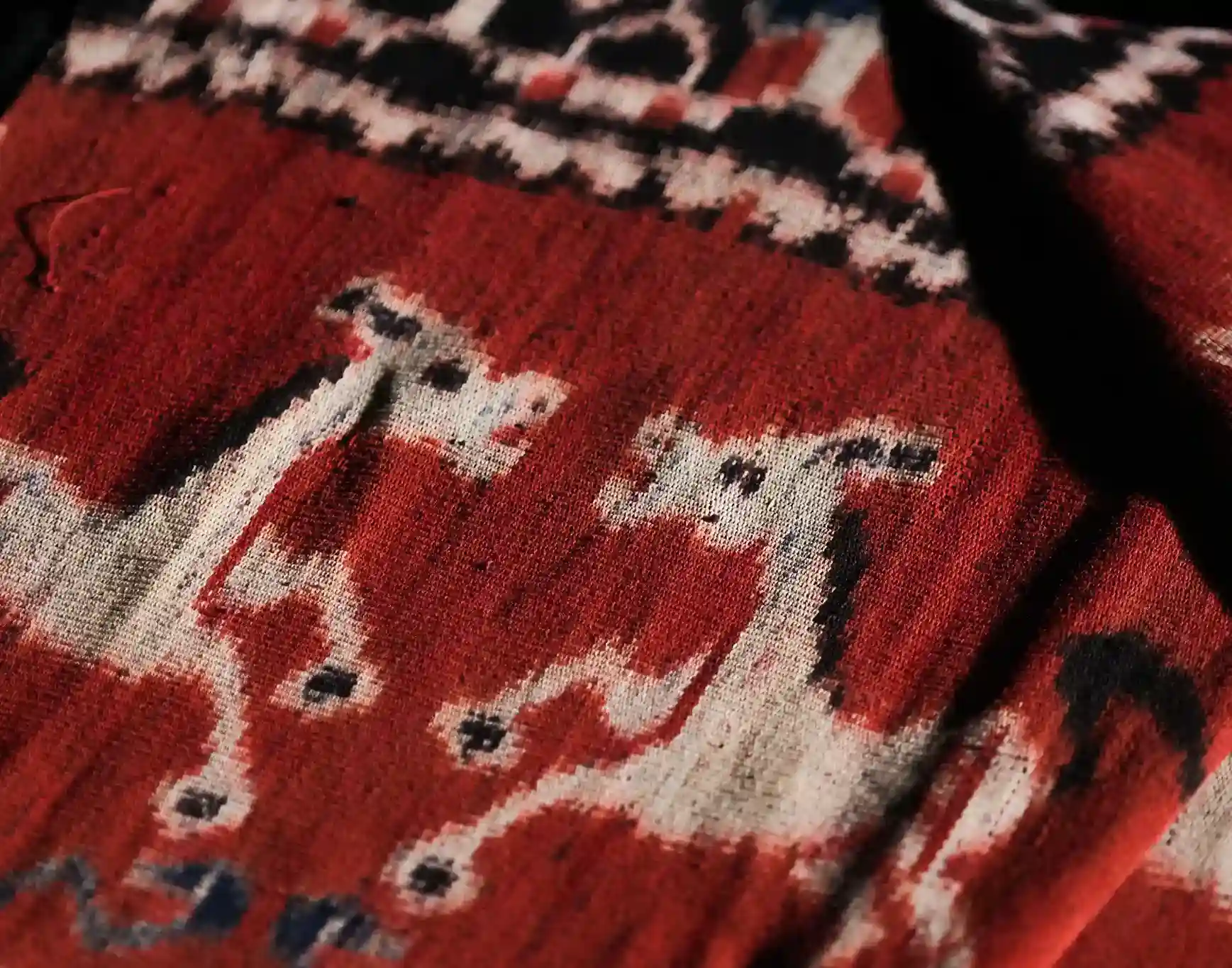 Red Sumba cloth with white horse figures woven into the field