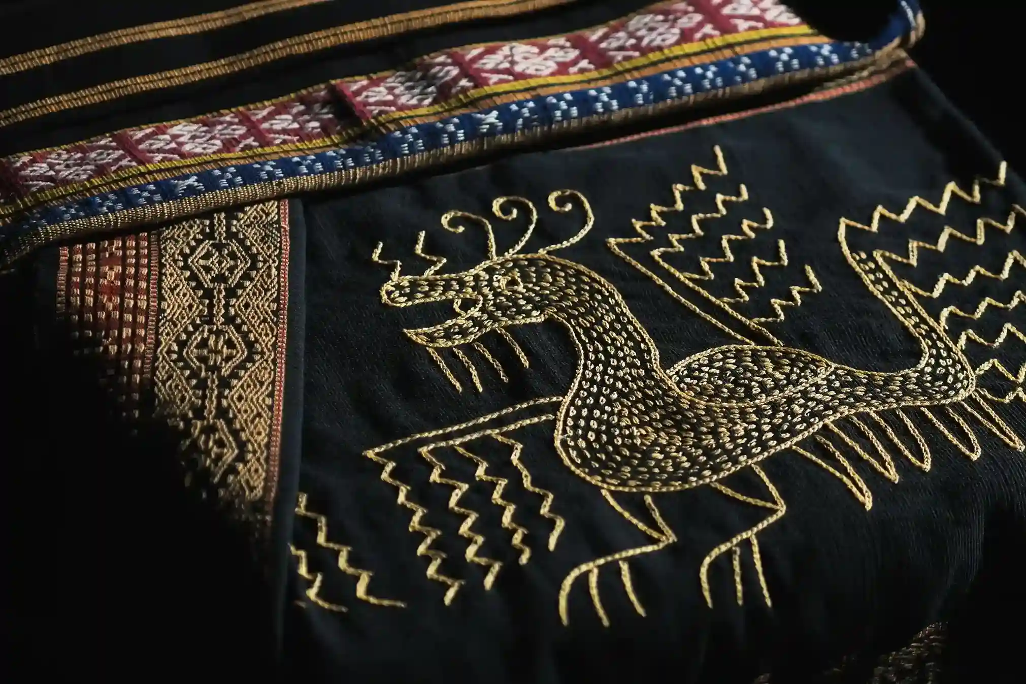 Black cloth with a gold rooster worked across the panel